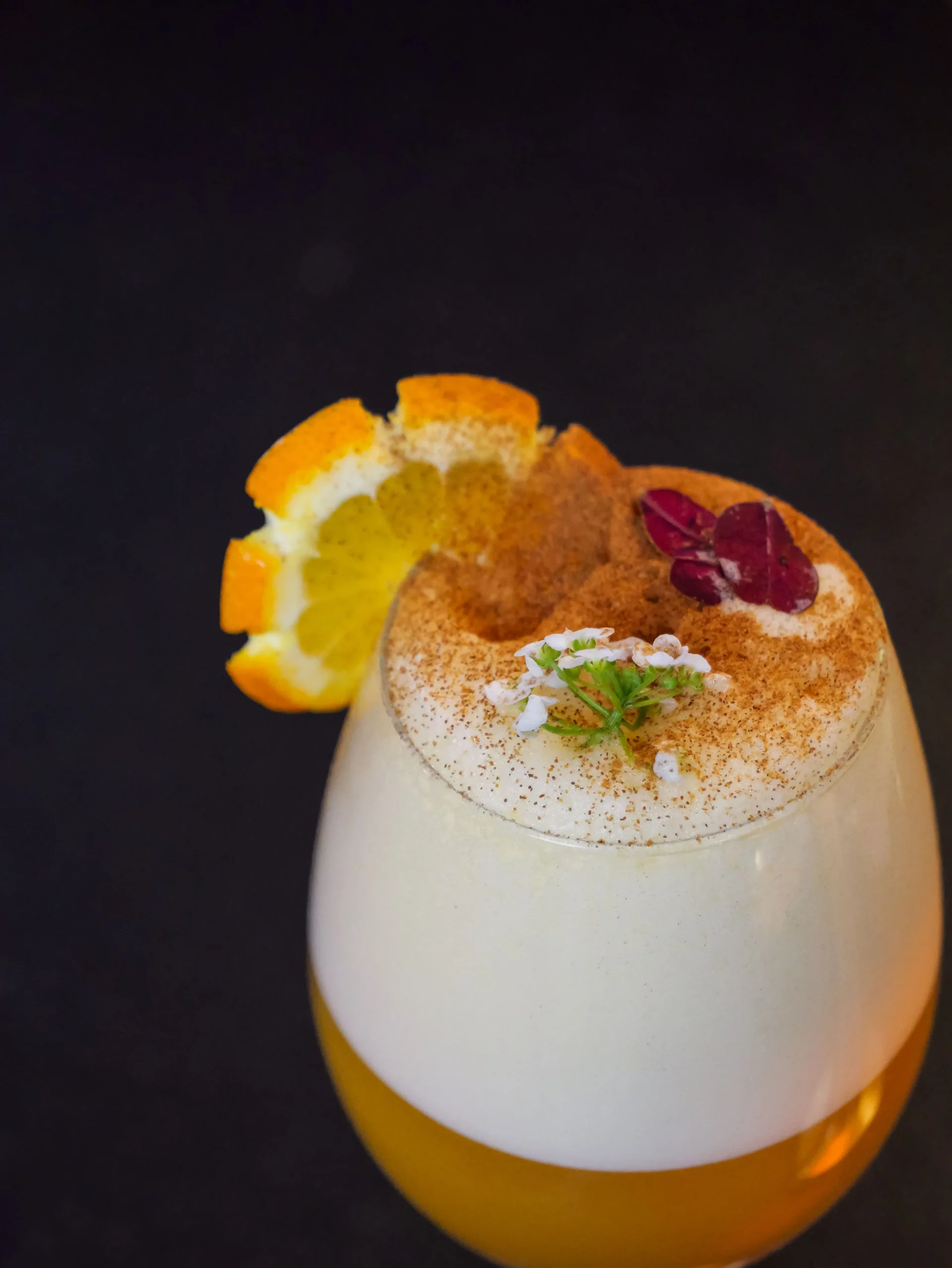 Photo prise du dessus d"un cocktail avec une mousse et des décorations dessus