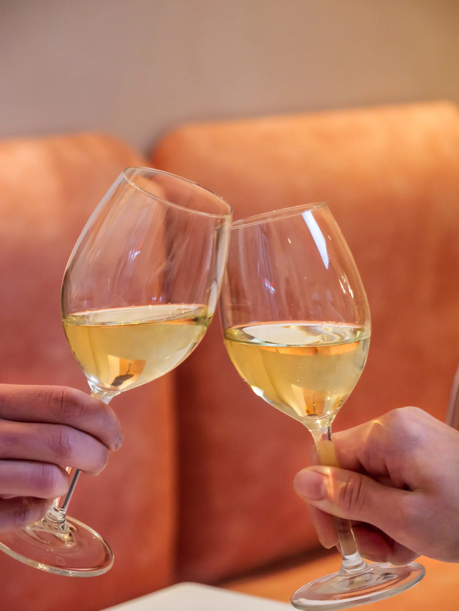 Photo deux deux mains qui tiennent des verres à vin et qui trinquent