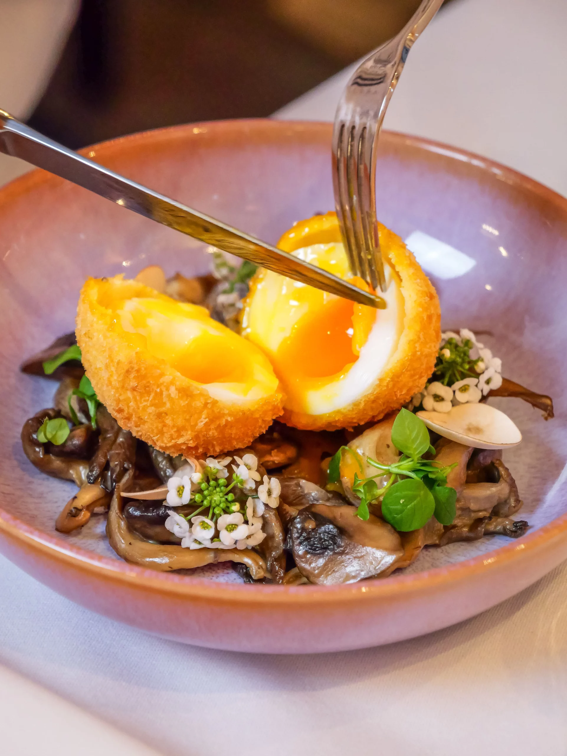 Photo d"un oeuf mollet pané sur lit de légumes sautés