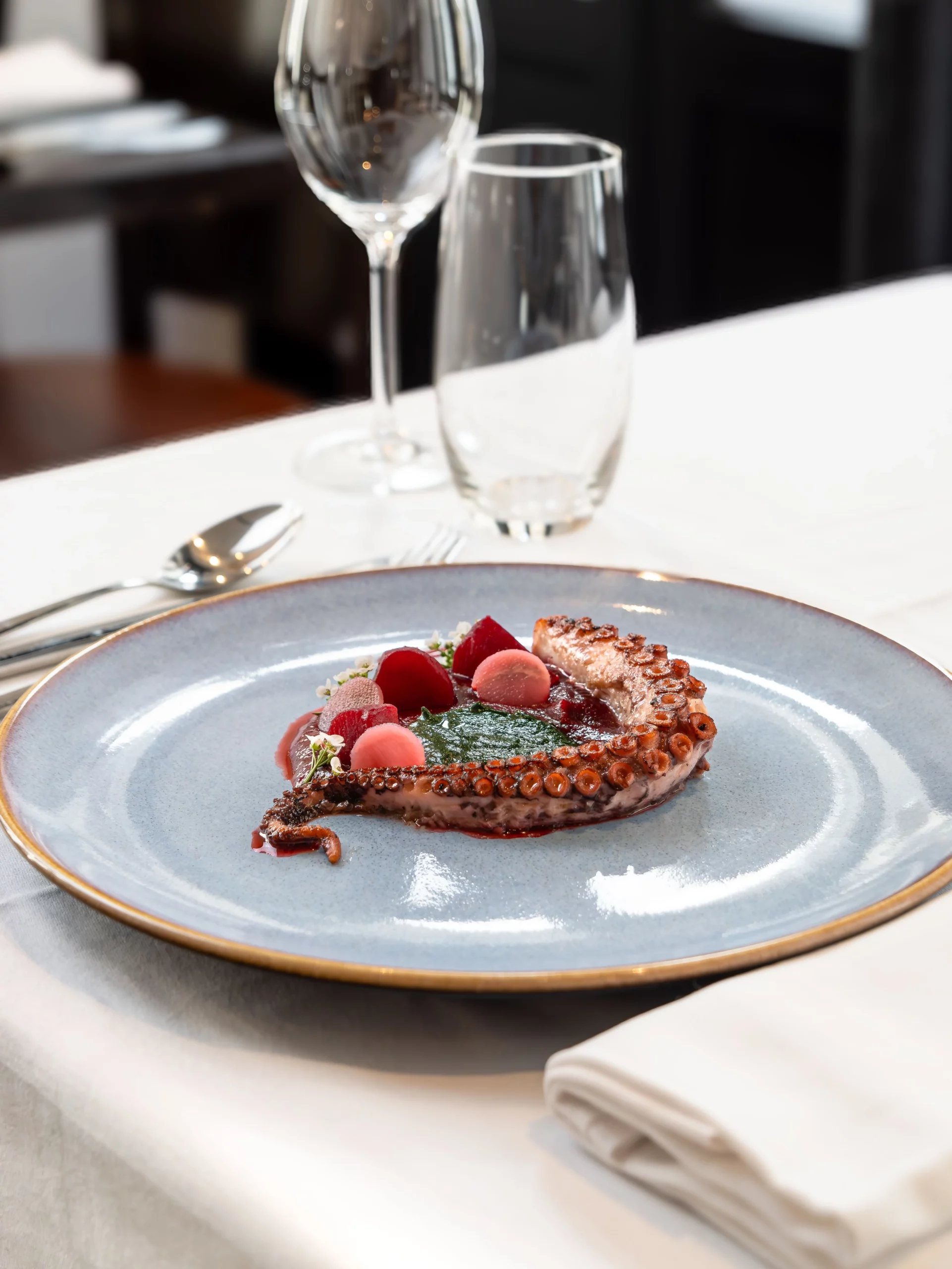 Photo d"une assiette d'entrée, avec un tentacule de poulpe et des légumes